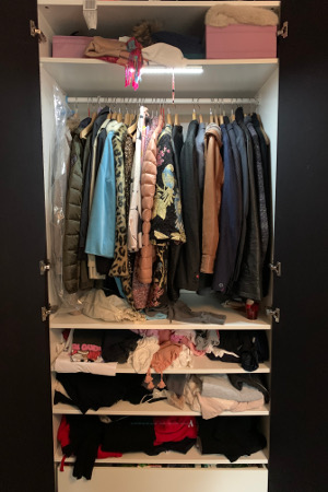 Ein unordentlicher Kleiderschrank vor einer Aufräum-Sitzung