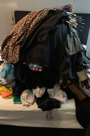 Der Inhalt des Kleiderschrankes aufgetürmt auf einem Bett